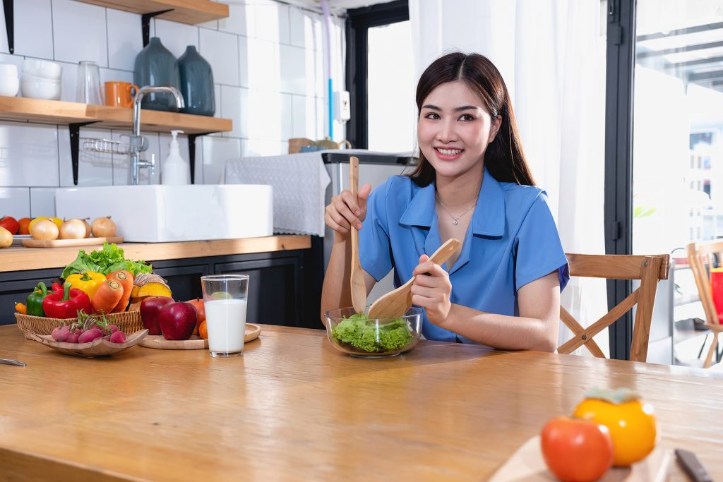 Diet, White-skinned Young Asian Woman In A Blue Shirt Eating Veg